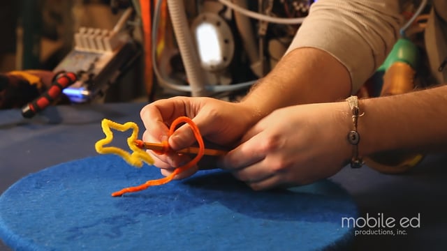 Continue to wrap the pipe cleaner around the pencil  | Handy Dan the Junkyard Man | Mobile Ed Productions