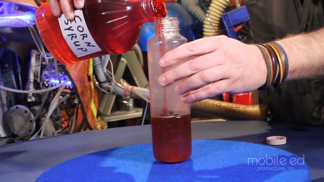 Next, pour the red corn syrup into the bottle