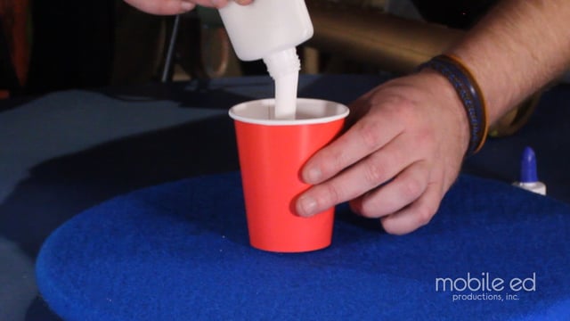 Add about an inch of white glue to the second cup.  Take off the cap, it makes it easier!